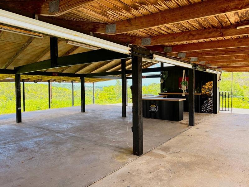Área techada con columnas de madera y la barra de El Pedregal