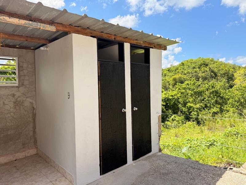 Baños con puertas negras junto al área verde